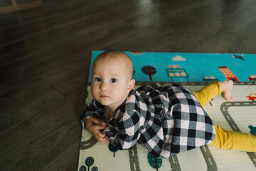 Cute baby girl playing with a toy on a play mat. Baby development.