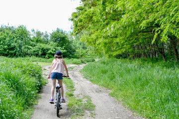 Young girl cyclist enjoy the beautiful sunrise on summer forest trail