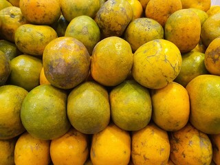 Close up pile of tasty fresh oranges sold at the market as a background.