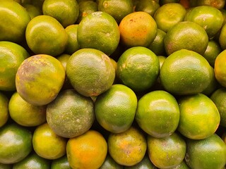 Close up pile of tasty fresh oranges sold at the market as a background.