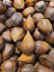 Close up pile of tasty fresh Salak or snake fruit sold at the market as a background.