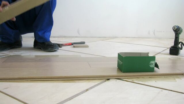 Two Workers were laid the parquet floor in room, time lapse