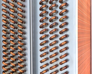 Close shot of copper plain tubes of a condenser coil.