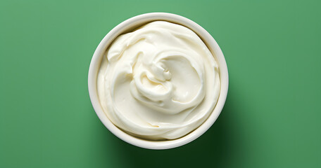 Top view of bowl with white quark or cream on side of green background with copy space - Powered by Adobe