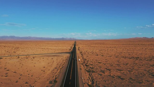 Modern black car driving in the desert on a street from California to Arizona. Cinematic landscape.