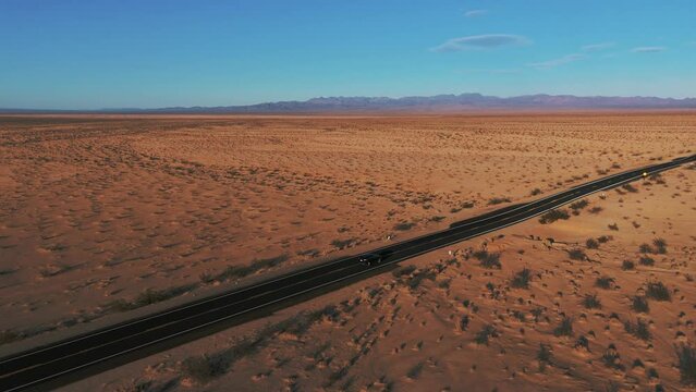 Modern car driving on a street in the desert from California to Arizona. Scenic sunset landscape.