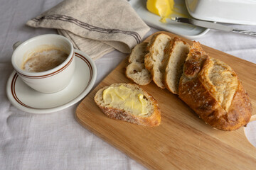 French breakfast charm: coffee with milk, sliced bread, and a butter dish. A delightful blend of morning simplicity and culinary elegance in a captivating tableau.