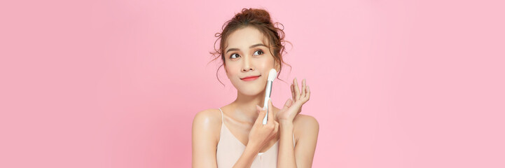 Closeup Beautiful  asian woman applying makeup with Cosmetic Powder Brush - obrazy, fototapety, plakaty