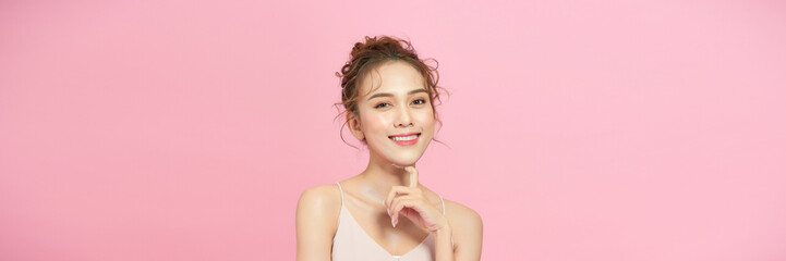 Beautiful young asian woman with clean fresh skin on pink background,