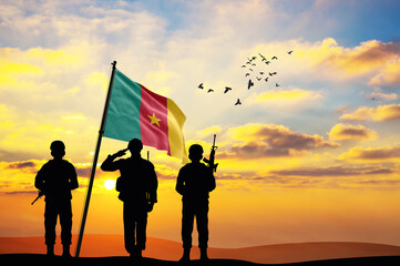 Silhouettes of soldiers with the Cameroon flag stand against the background of a sunset or sunrise. Concept of national holidays. Commemoration Day.