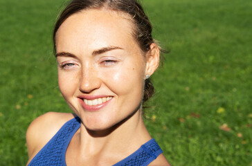 Portrait of a young athletic woman in the morning park before training.