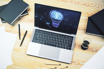 Creative idea concept with light bulb and human brain illustration on modern laptop screen. Neural...