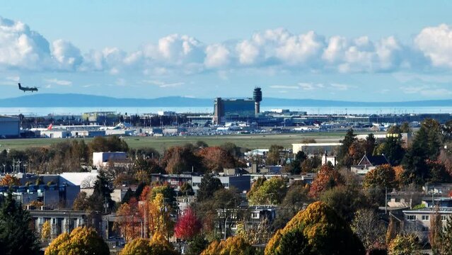 YVR Station And Control Tower At Vancouver International Airport With Aircraft Landing. wide aerial shot