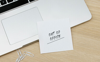 Out of office written on a card at the desk - obrazy, fototapety, plakaty