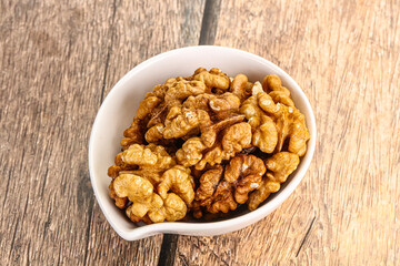 Cracked unshelled walnut in the bowl