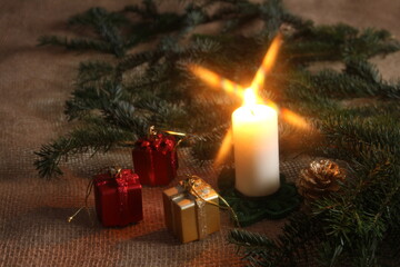 A flickering flame illuminates the table adorned with presents, casting a warm and inviting glow.
