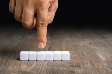 A human hand shows a row of small cubes