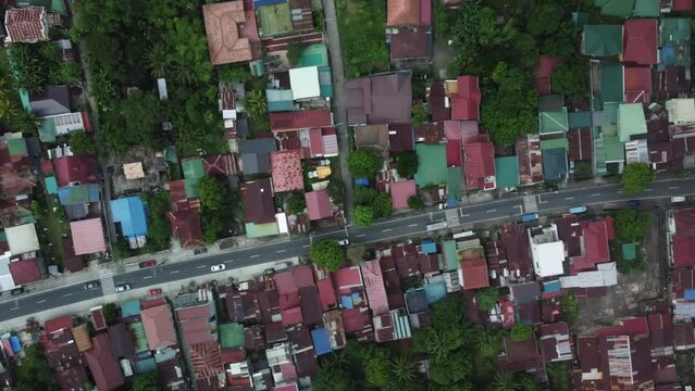 Top down drone shot of Philippine Provincial Highway with cars, surrounded by trees and houses