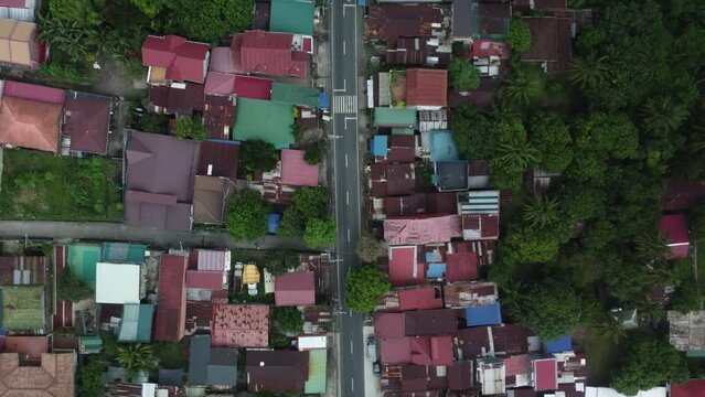 Top down drone shot of Philippine Provincial Highway with cars, surrounded by trees and houses
