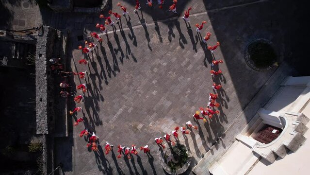 Birdseye Aerial View, Majorette Girls in Red Uniforms Performing on City Square. Top Down Drone Shot
