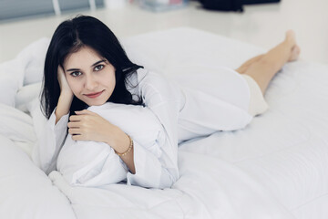  young girl on bed in modern apartment in the morning. Healthy sleeping concept. fresh relaxed young woman resting sitting in bed wear pajamas good morning after wakeup