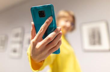 The phone is in the hands of a girl wearing a yellow jacket