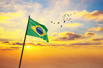 Waving flag of Brazil against the background of a sunset or sunrise. Brazil flag for Independence...