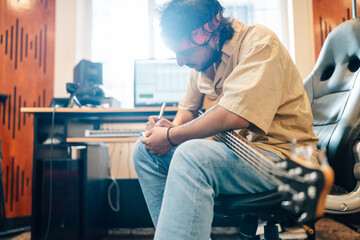 Musician writing a letter in a music home studio