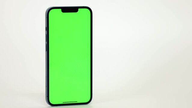 Close Up of Mobile Phone With Green Mock-up Screen On White Background