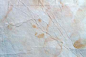 The texture of old crumpled paper with a blue tint. Old texture with spots and cracks.