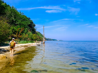 Woman tourist walk across wild coast of Baltic Sea. Puck Bay.