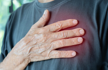 Upset stressed mature middle aged man feeling pain ache touching chest having heart attack.