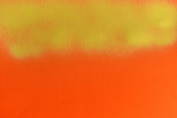 yellow spray paint on orange paper background