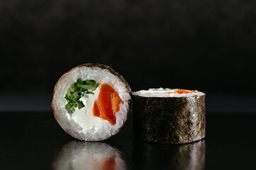 Japanese sushi roll on a dark background with reflection