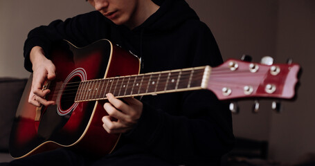 Fototapeta na wymiar Portrait of teenager boy playing guitar