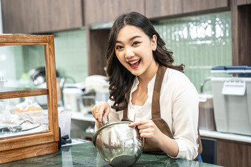 Beautiful woman preparing food near counter with happy expression. She working in coffee shop with...