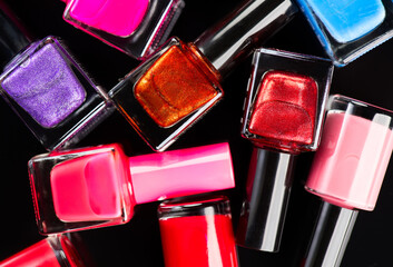 Nail polish colorful bottles isolated on black background, various colors shellac backdrop....