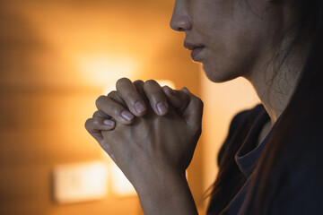 Christian woman praying in bedroom, woman hands praying to god, begging for forgiveness and believe in goodness. Christian life crisis prayer to god. Christian life crisis prayer to god.