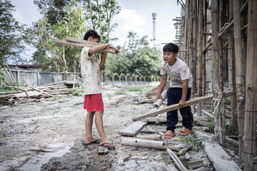 Children forced to work hard at construction site, child labor concept, poor children victims of...