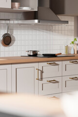 A bright beige-toned kitchen interior with sunlight 
coming through the window.