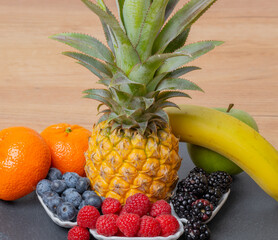 Ananas Frucht mit Himbeeren, Brombeeren, Heidelbeeren, Mandarine, Banane, Apfel, auf einer...