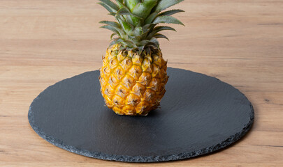 Ananas Frucht auf einer Schiefertafel und Holzplatte