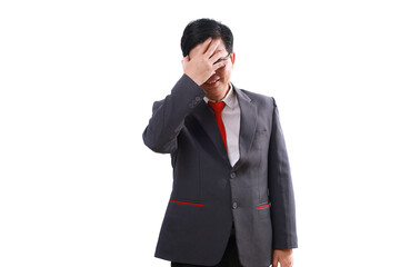 Stressed asian businessman standing while holding his head, suffering from headache. Isolated on white