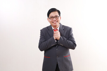 Relieved asian businessman standing while looking at the camera