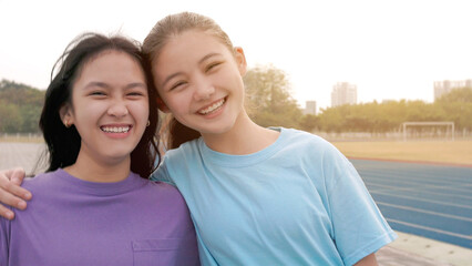 happy young school girls  standing together smiling and looking at the camera