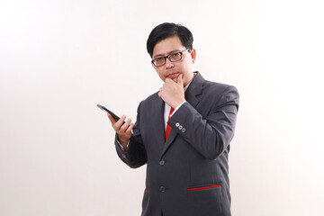 Confused asian businessman holding a cell phone while thinking something, Isolated on white