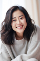 Smiling young Asian woman at home