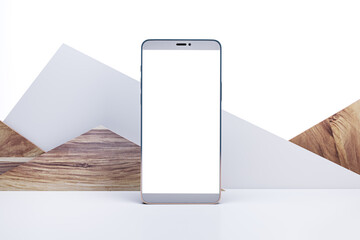 Empty mobile phone on creative decorative triangular mountain background with mock up space. Wooden...