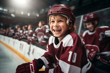 Smiling child hockey player on the ice of a hockey stadium. Hockey training - obrazy, fototapety, plakaty