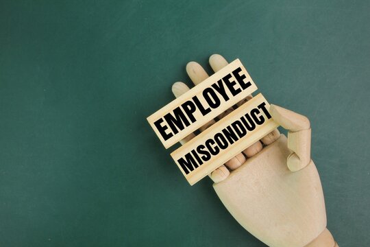 wooden hand and jayu with the word employee misconduct. the concept of employee misconduct or employee fault